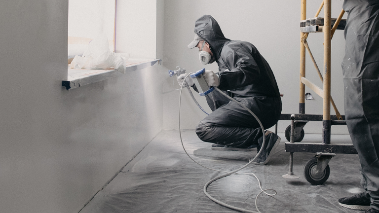 Workers spraying along wall